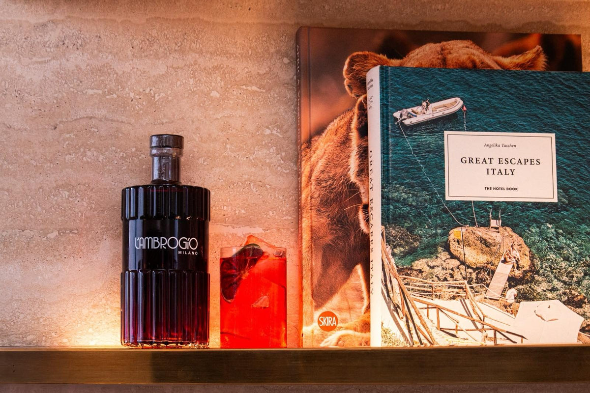 Still life di L'Ambrogio Milano con bicchiere e libro fotografico in luce calda