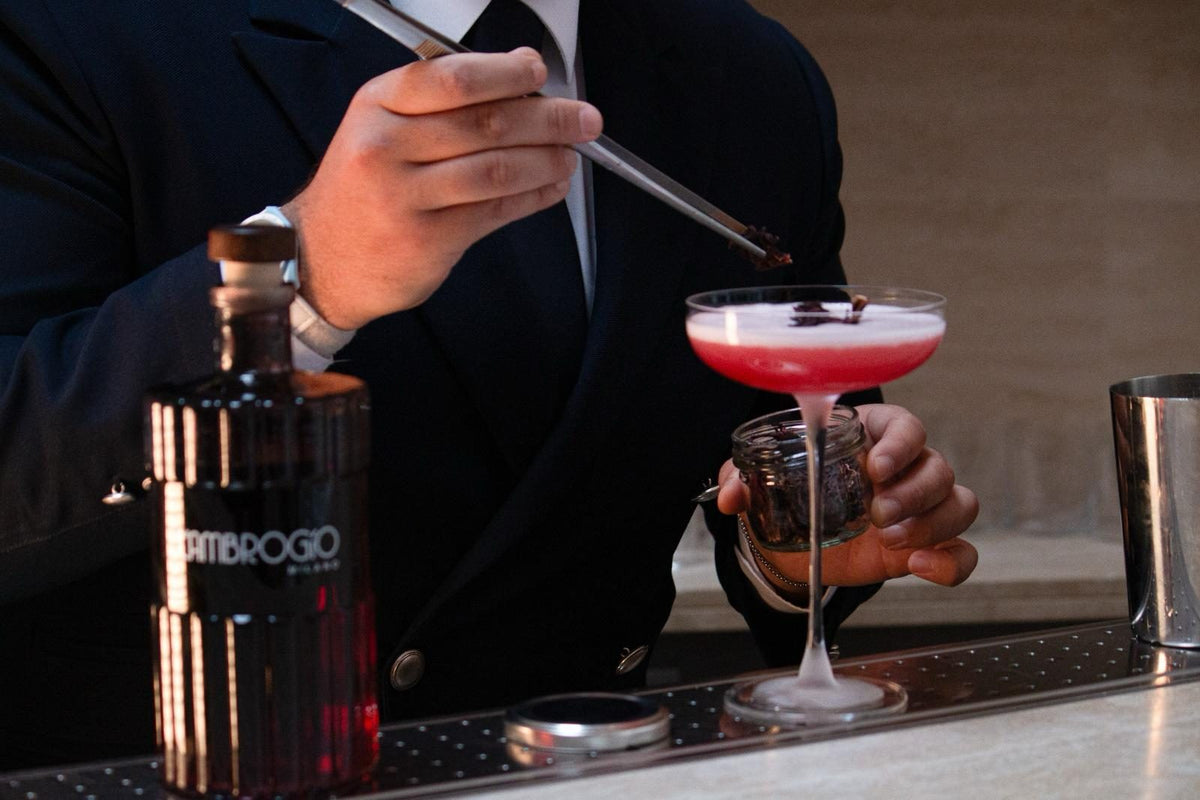 Il bartender completa un cocktail con L'Ambrogio Milano dietro al bancone