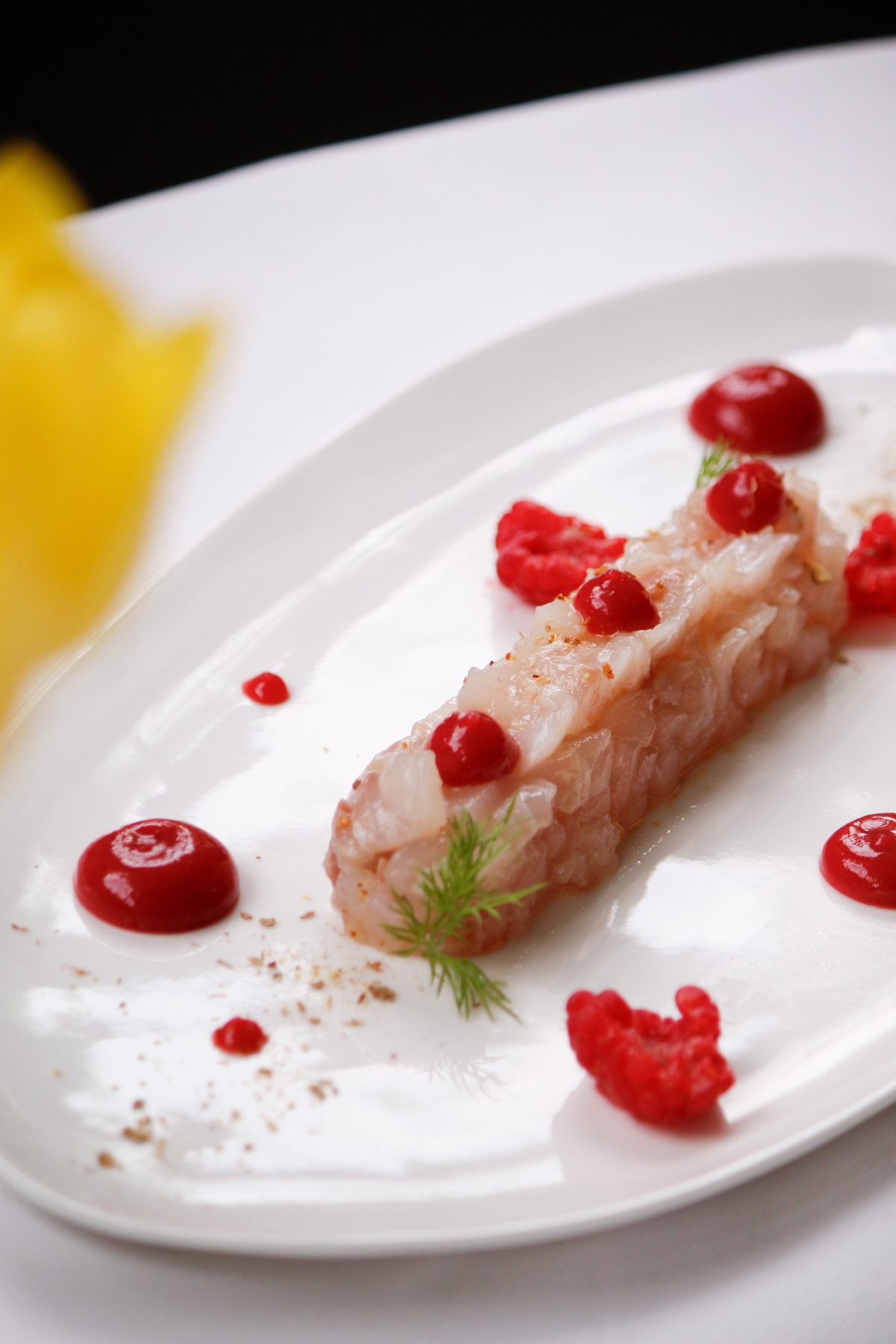 Crudo di gambero con gocce di lampone servito su piatto bianco al Ristorante Da Alice