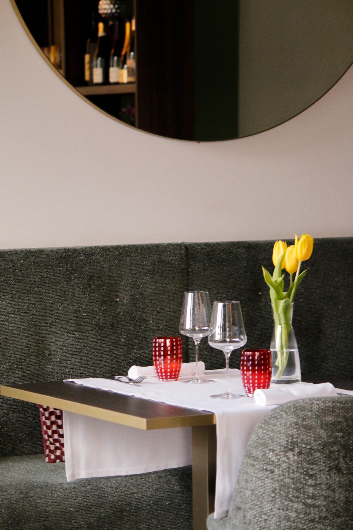 Tavolo apparecchiato con tulipani gialli e calici nella sala del Ristorante Da Alice
