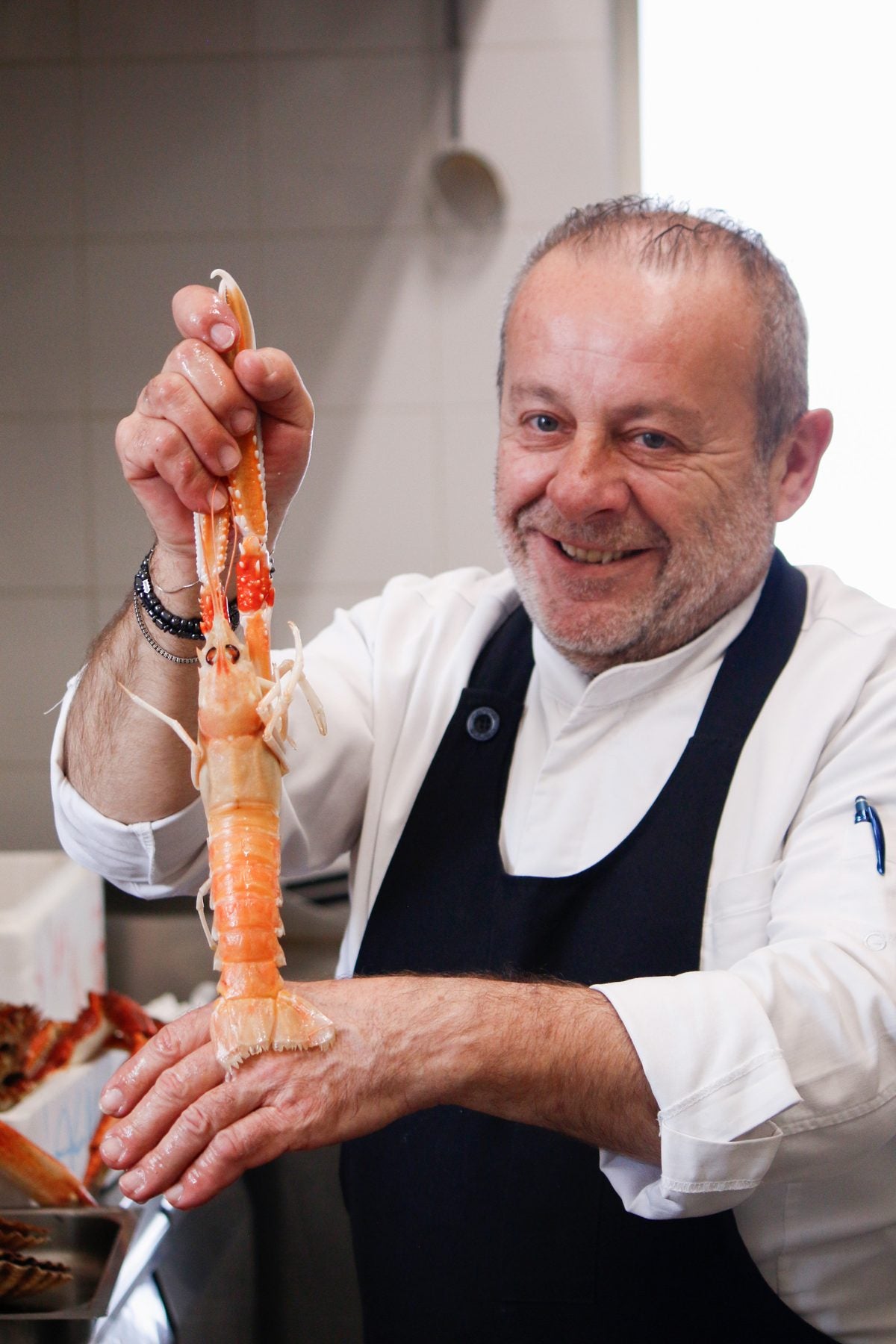 Lo chef del Ristorante Da Alice mostra gli scampi freschi nella cucina del ristorante