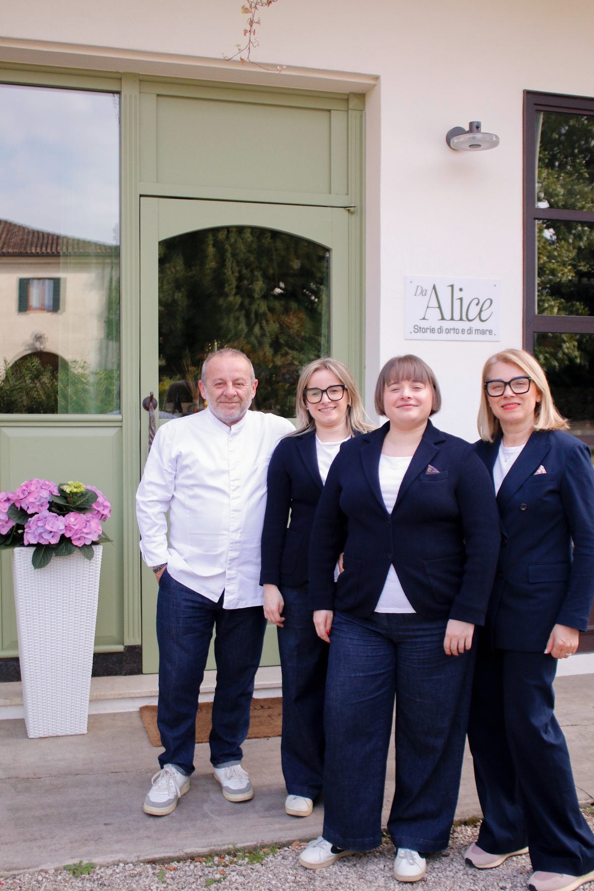 Lo chef e la squadra di sala del Ristorante Da Alice davanti all'insegna del locale